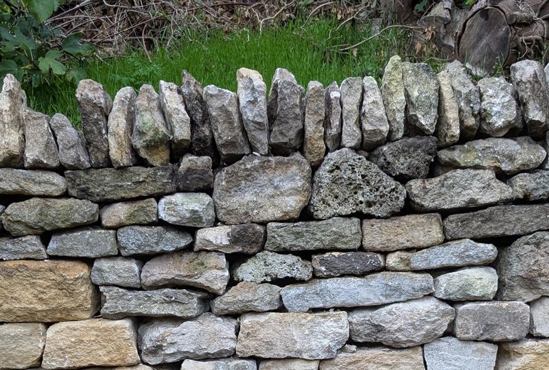 Close-up of cock-and-hen coping on a Cotswold dry stone wall