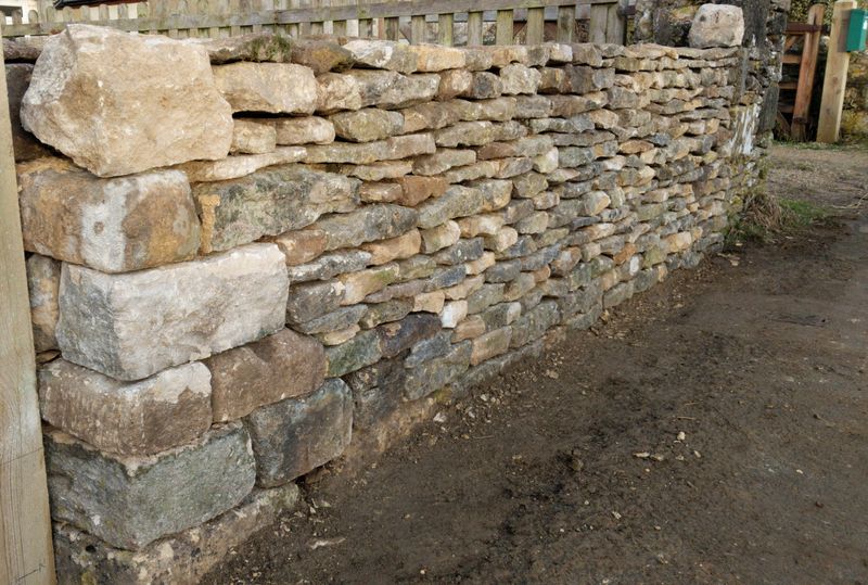 New wall built up to a gatepost