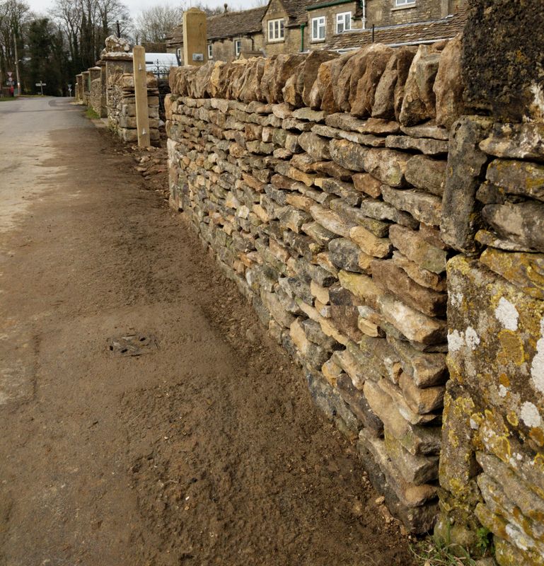 Rebuilt wall along a village lane